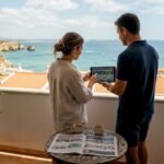 Couple on Lagos Algarve balcony with property tablet