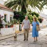 Couple walking in Algarve neighborhood with sunlight